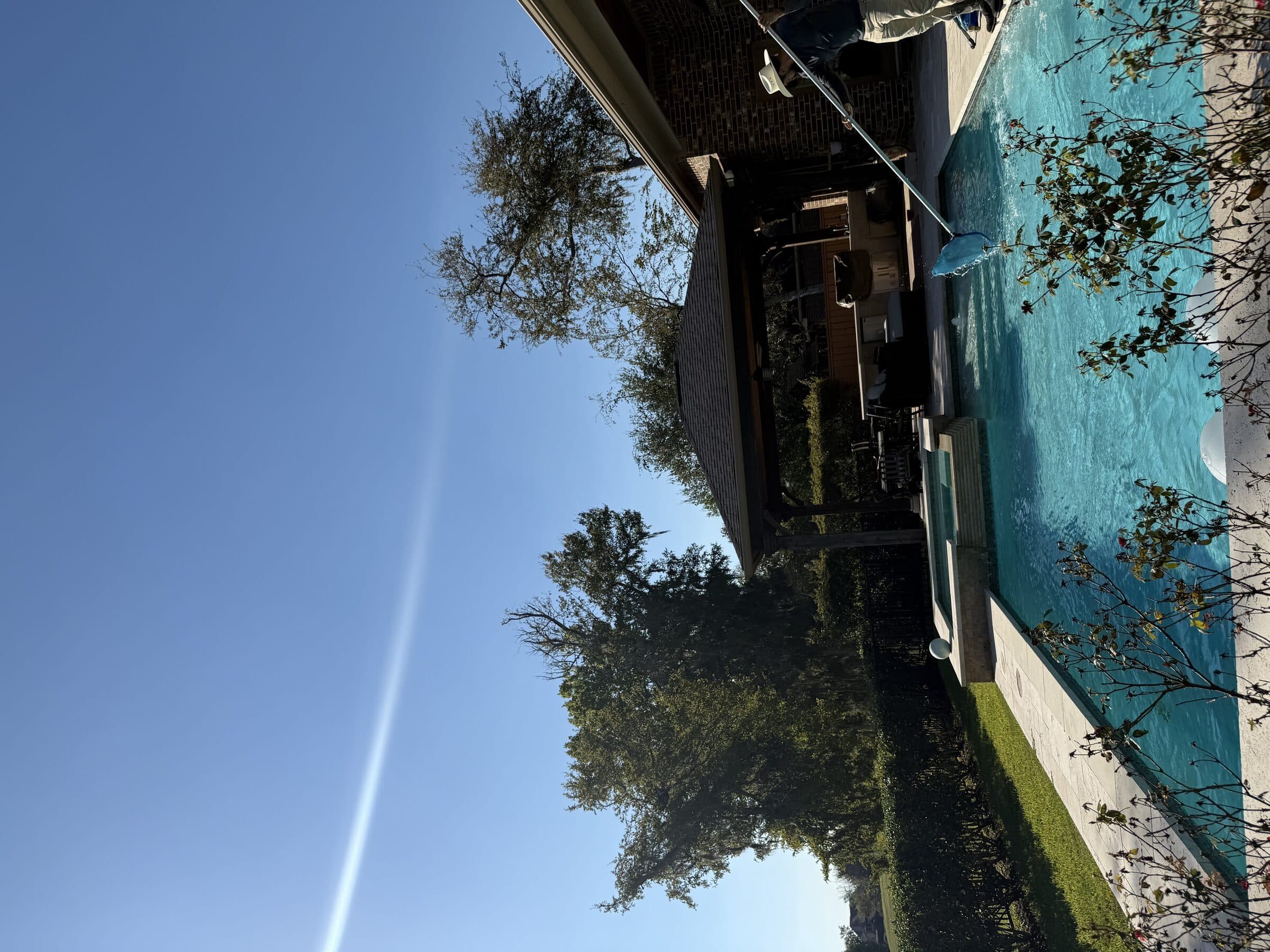 Pool technician brushing pool walls