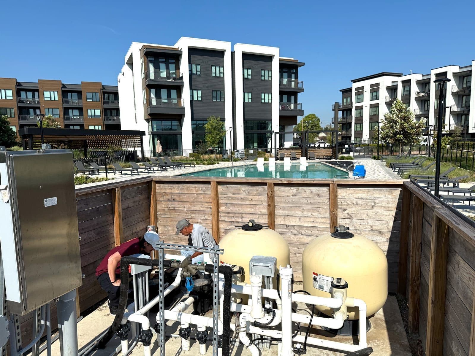 Technicians servicing commercial pool equipment